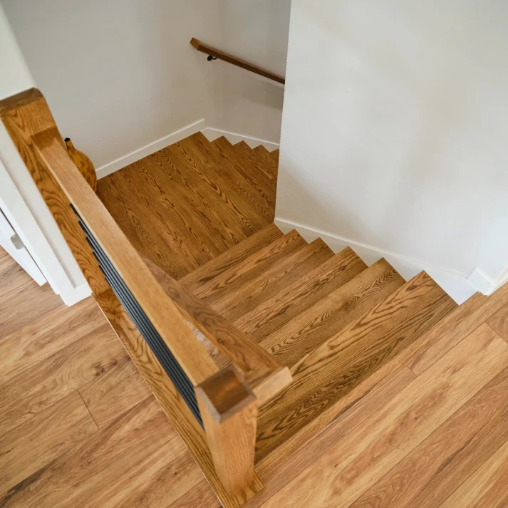 Wooden staircase with handrail and hardwood flooring.