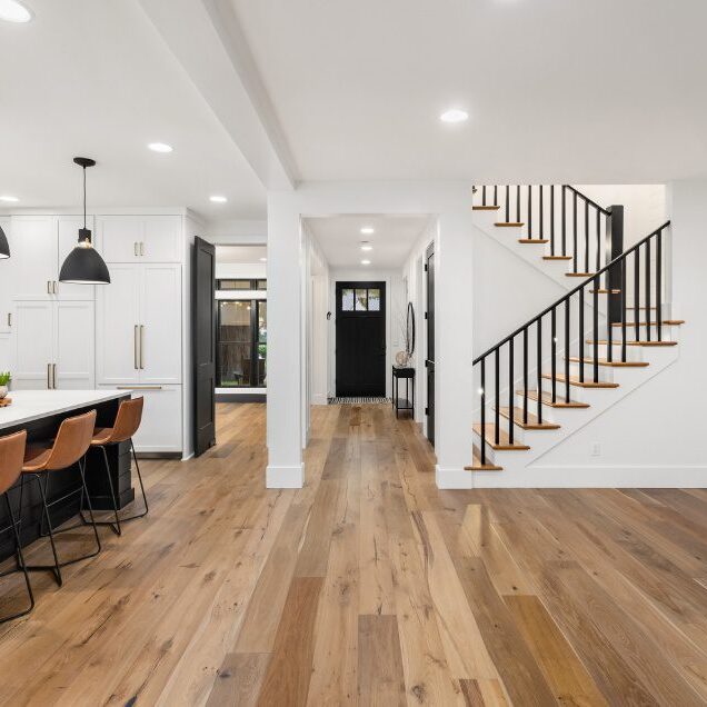 Modern kitchen and hallway with wooden flooring.